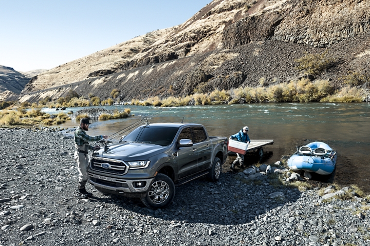 Men at river bank unloading rubber raft from trailer on 2019 Ford Ranger