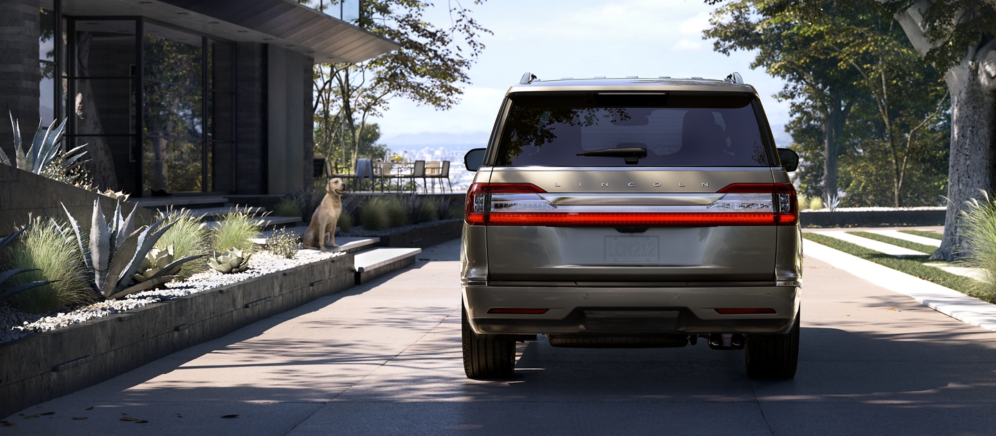 A Lincoln Navigator is shown parked in the driveway of a modern home