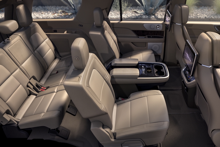 A wide shot of the 2020 Lincoln Navigator interior bathed in soft inviting light shows off the spacious design of the second and third row seating